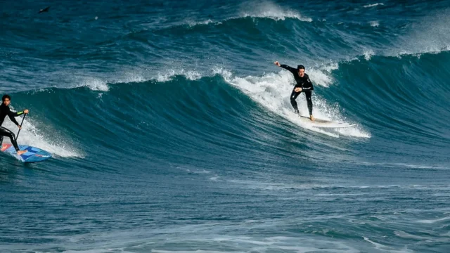 Two surfers riding large ocean waves