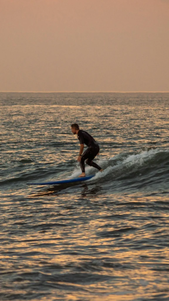 Surfer riding a wave at sunset
