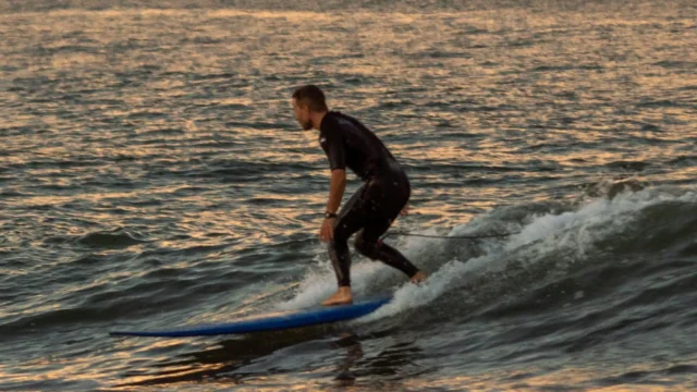 Surfer riding a wave at sunset