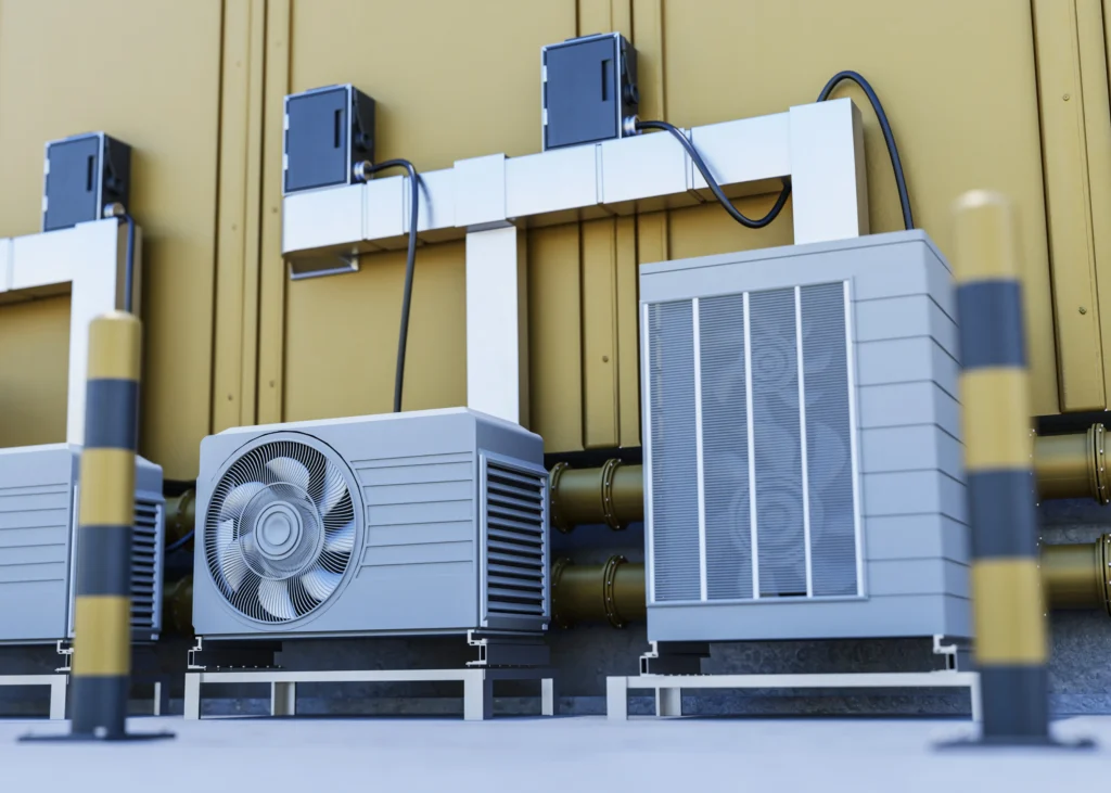 3D render of industrial air conditioning units and heat pumps mounted outside a yellow building with pipes and electrical cables
