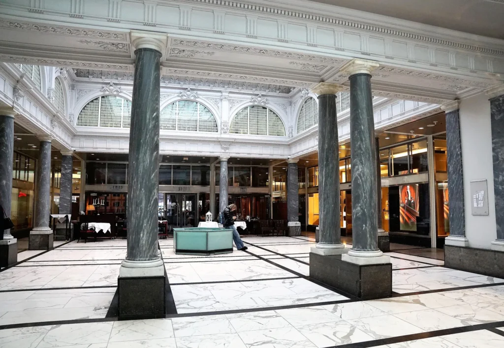 Grand marble banking hall interior with tall green marble columns, ornate ceiling and arched windows representing Peach Bank