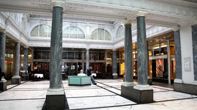 Grand marble banking hall interior with tall green marble columns, ornate ceiling and arched windows representing Peach Bank